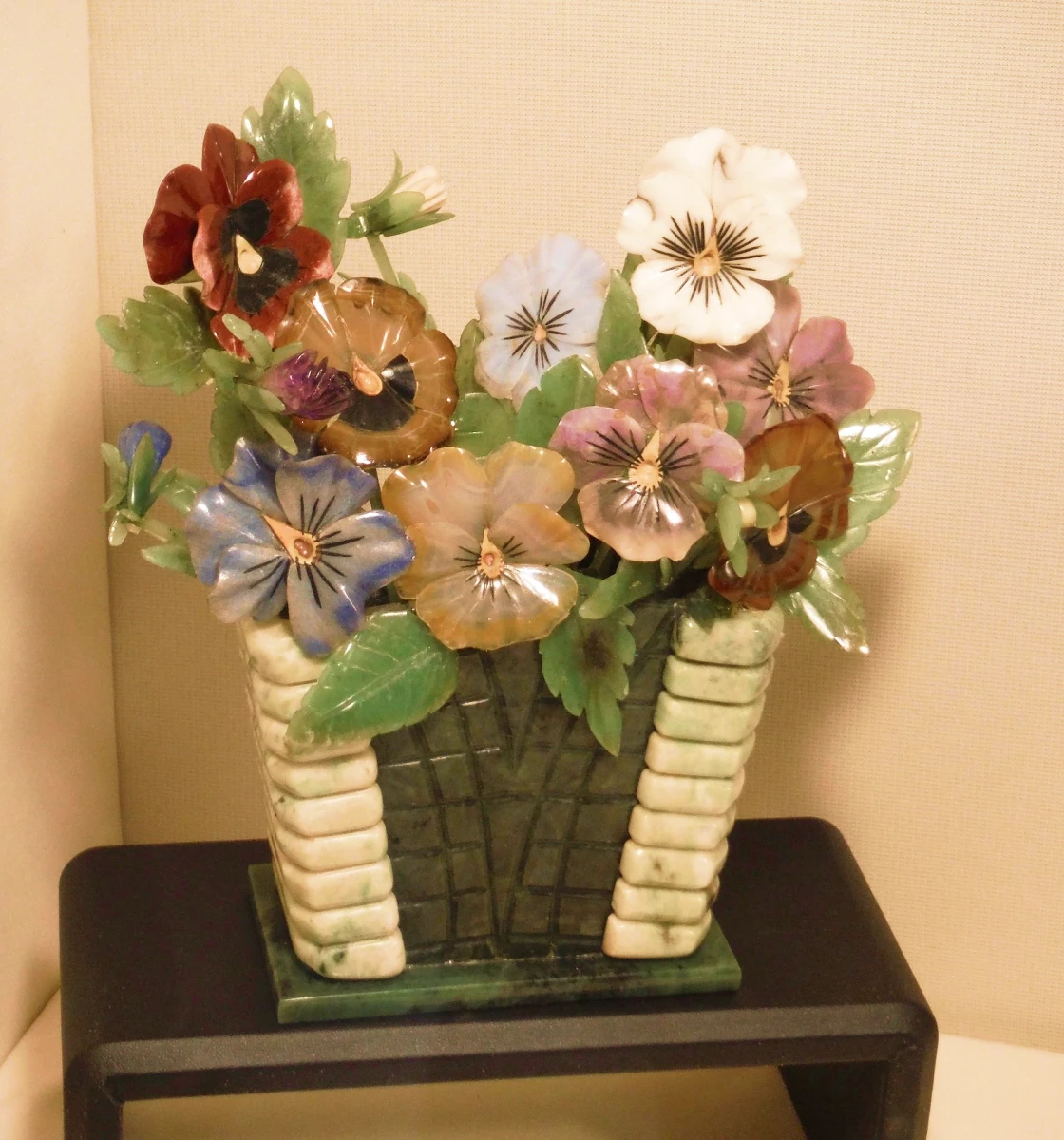 Colorful ceramic flowers in a decorative vase.