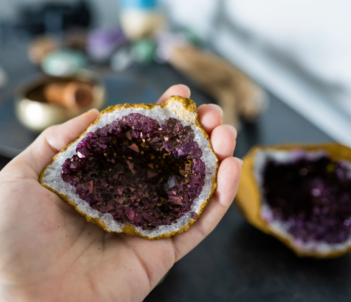 Hand holding a purple geode crystal.